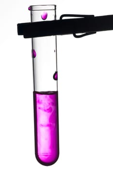 Test tube on clamp with violet liquid