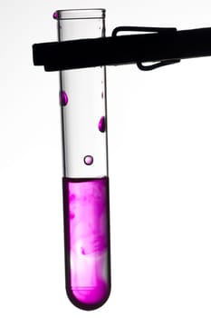 Test tube on clamp with violet liquid