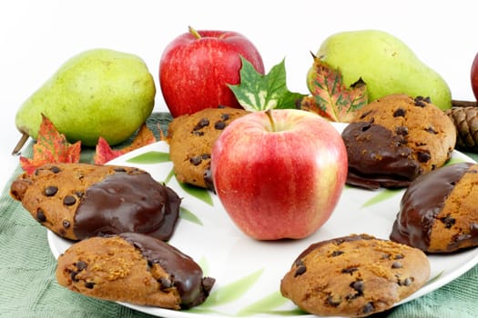 Fall treats dipped in chocolate surrounded by apples, pears, leaves, pine cone.
