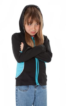 Sad young girl, arms crossed, standing on white background.