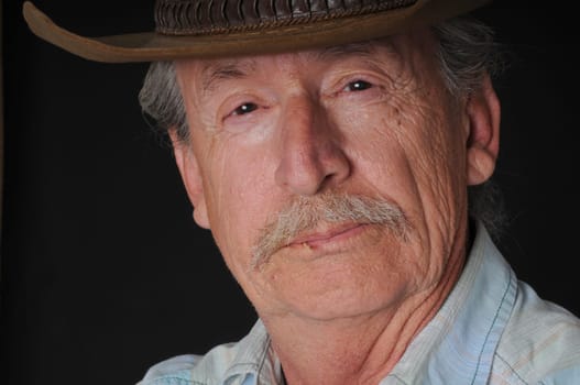 Portrait of an old cowboy with a toothpiclk in his mouth