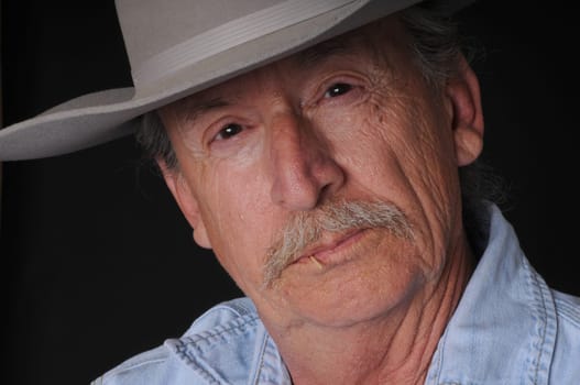Portrait of an old cowboy with a toothpick in his mouth