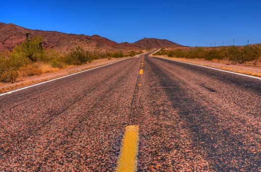 Lonely Desert road leading of into the mountains