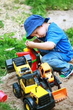 Cute boy playing with digger at the playground