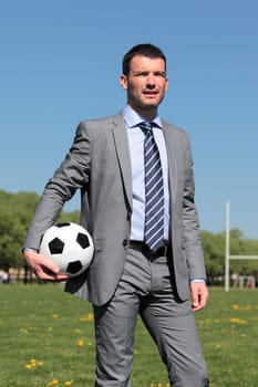 businessman with ball in a park in summer