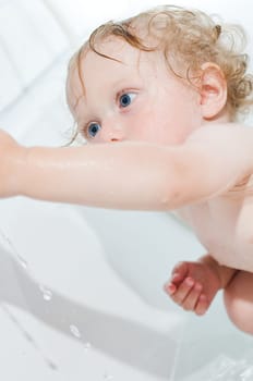 Toddler having fun bathing in the tub