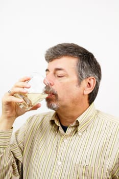 Mature male drinking a glass of organic aloe vera juice.