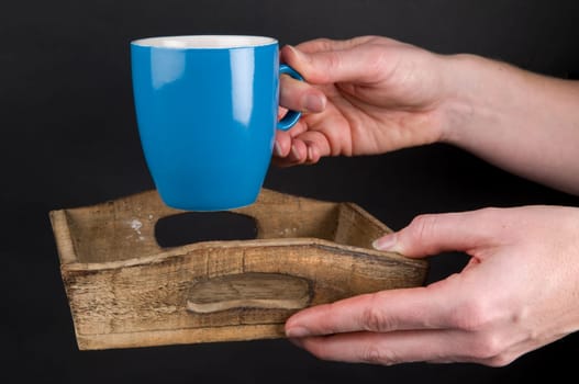 Woman&#039 s hands holding a plate with a cup of coffee.
