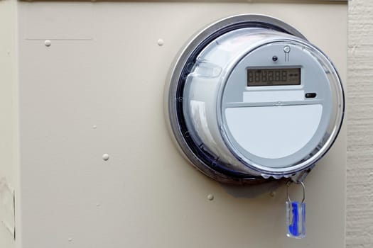 Close-up of a digital energy monitor on the exterior of a residential home.