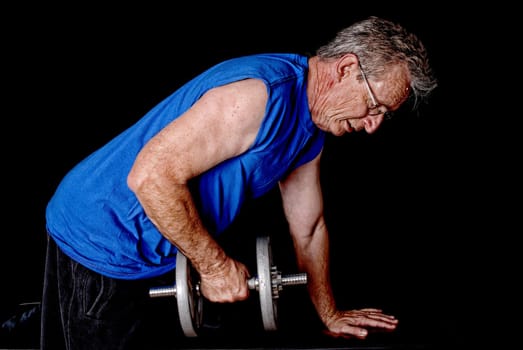 Senior man weight traing and exercising with weights
