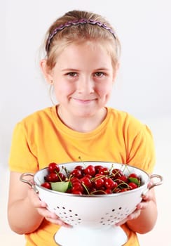 Cute child holding a bowl of fresh cherries