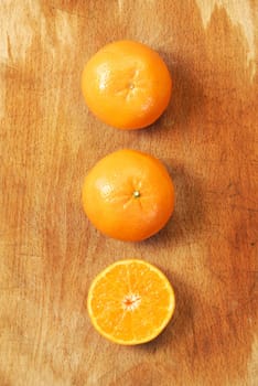 Half of orange and the whole orange. On wood background.