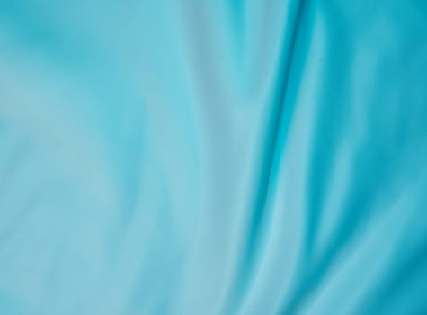 Light blue fabric with gentle folds creating a soft, minimalist texture. Ideal for backgrounds, templates, and design projects with copy space