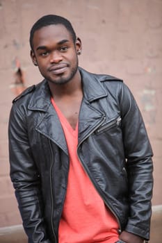 Young teenager of african origin with black leather jacket smiling