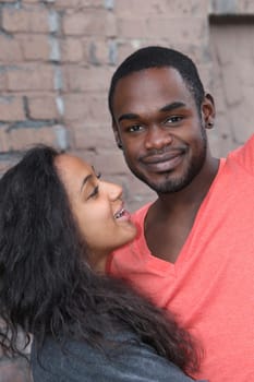 Young couple of different origins hugging and smiling