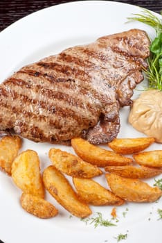 Juicy beef steak stuffed with beef tongue and cheese served with potatoes, greenery and sauce