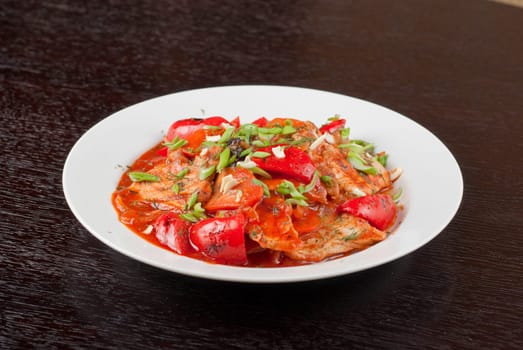 pork meat with tomato, pepper, prunes, garlic and green onion