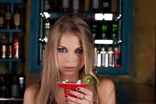Girl with cocktail on bar counter background