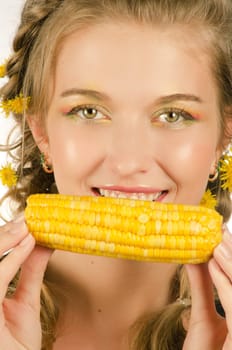 Close-up portrait of young beauty woman eating corn-cob on a white