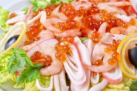 Salad with shrimps, caviar, calamaries, lettuce, lemon and olive