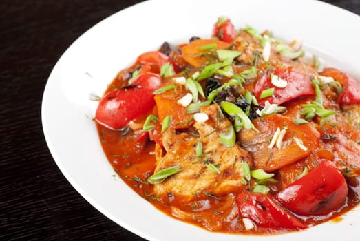 pork meat with tomato, pepper, prunes, garlic and green onion