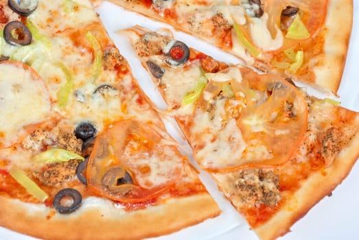 seafood pizza closeup with salmon, shrimps, tomato, pepper, olive and mozzarella cheese on a white background