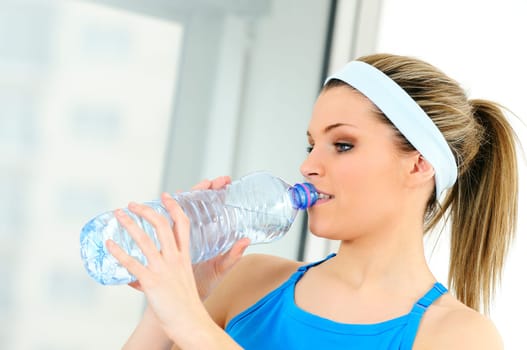 young sportive adult is drinking fresh water
