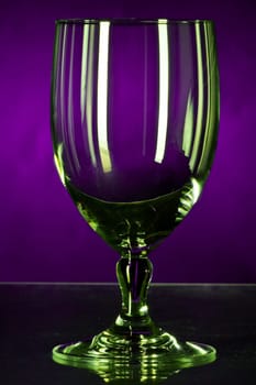 Empty glass shimmering in money against violet background