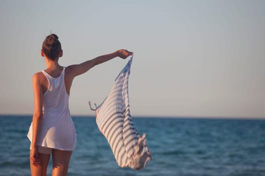 woman holding veil or scarf at the beach