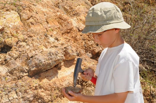 Young boy studing geology out in the field