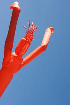 Blown up high by a windmachine a fabrique puppet is dancing in the air