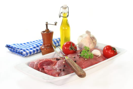 two raw pork steaks on a white serving platter