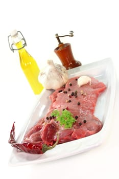 two raw pork steaks on a white serving platter