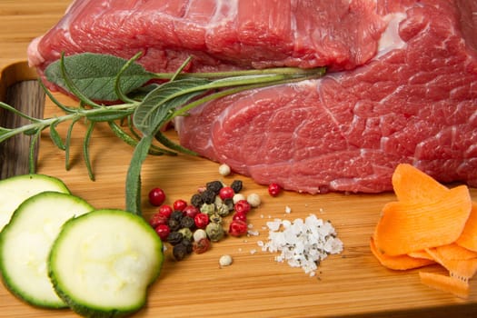 red meat with pepper and rosemary on wooden board