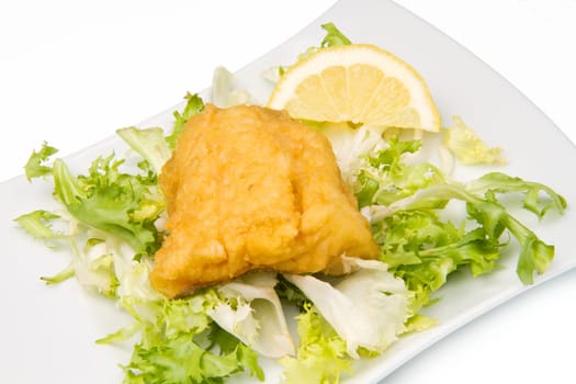 fried cod fish with fresh salad and lemon slice