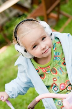 Shot of little girl in headphones playing outside