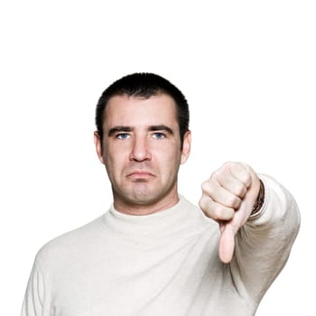 Portrait of a handsome expressive man showing thumbs down sign in studio on white isolated background