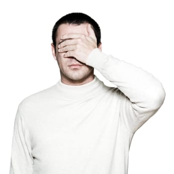 Portrait of a handsome man covering his eyes with hand in studio on white isolated background