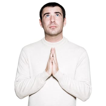 Portrait of a handsome man with hands clasped in prayer in studio on white isolated background