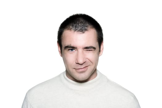 Portrait of a handsome cunning man winking in studio on white isolated background