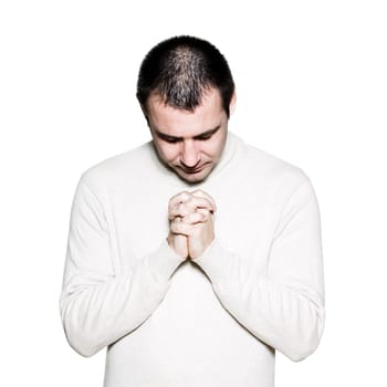 Portrait of a mature man praying with hands clasped in studio on white isolated background