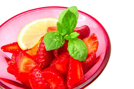 Strawberries in a cup decorated with a lemon on white background