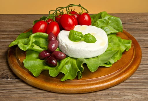 fresh cheese with salad, tomatoes and black olives