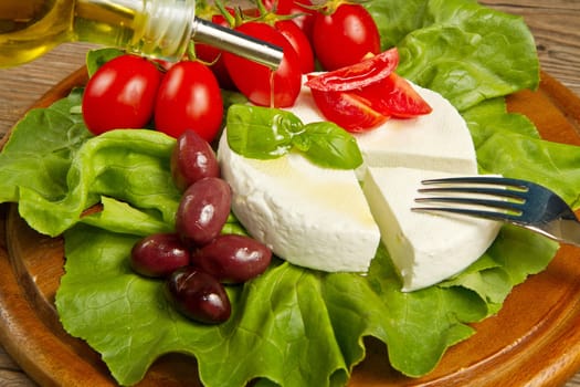 fresh cheese with salad, tomatoes and black olives