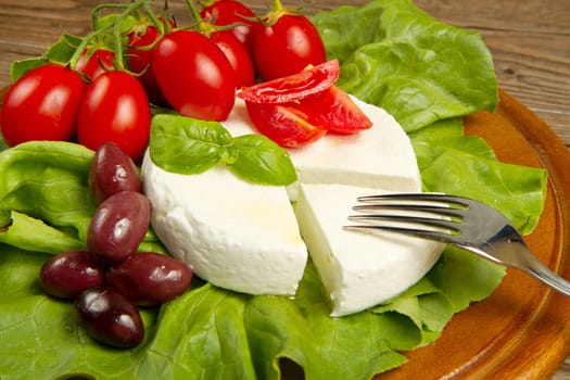 fresh cheese with salad, tomatoes and black olives
