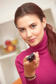 happy woman with remote control watching television