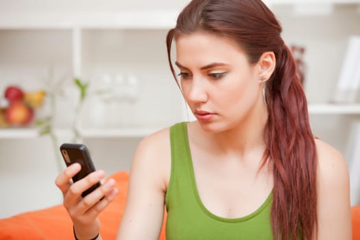 surprised woman with mobile phone at home