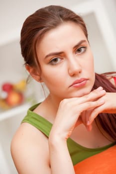 sad and depressed woman sitting on sofa at home