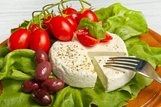 fresh cheese with salad, tomatoes and black olives