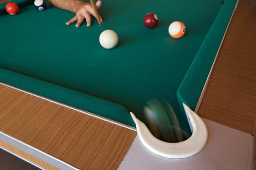 Playing billiards with balls on a green felt table